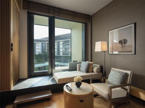 a living room with a couch and a large window at Banyan Tree Dubai at Bluewaters in Dubai