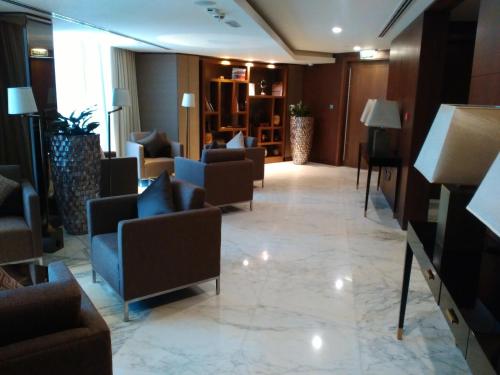 a lobby of a hotel with couches and chairs at Grand Millennium Muscat in Muscat