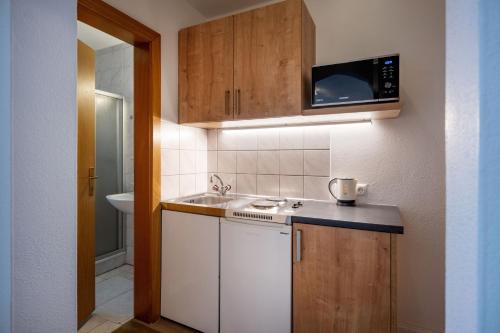 a small kitchen with a sink and a microwave at Gästehaus Wildauer in Ebbs