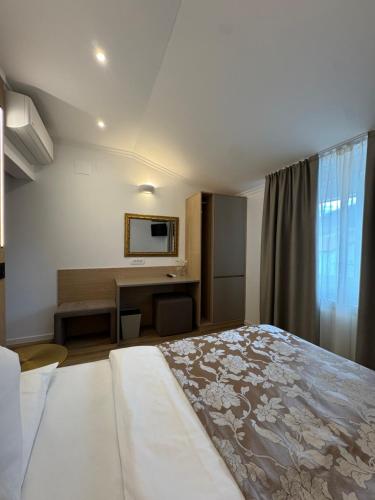 a hotel room with a bed and a desk at Hotel Grahor Depandance in Sežana