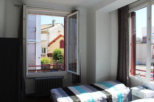 - une chambre avec un lit et une fenêtre avec vue dans l'établissement Cottage de Noëlle, à Limoges