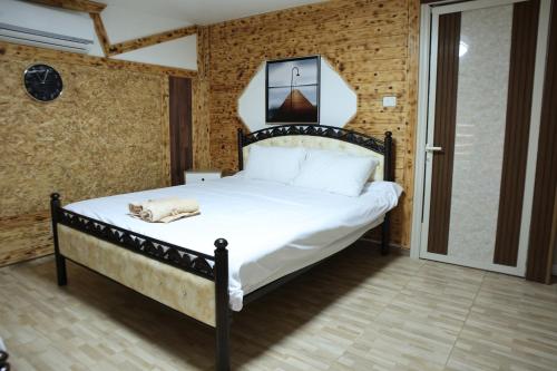 a bedroom with a large bed with white sheets at נוף הכפר - 6 חדרי אירוח לזוגות ומשפחות עם ג'קוזי ובריכה מחוממת משותפים במתחם in Buq‘ātā