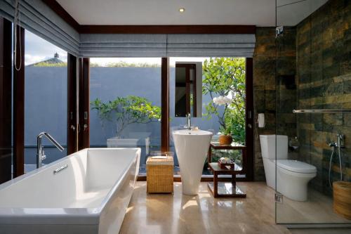 a bathroom with a tub and a sink and a toilet at Seminyak Icon - by Karaniya Experience - CHSE certified in Seminyak