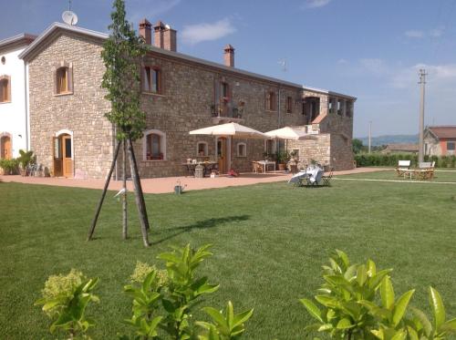 a large stone house with a tree in the yard at Masseria Fontana dei Fieri in Pietrelcina