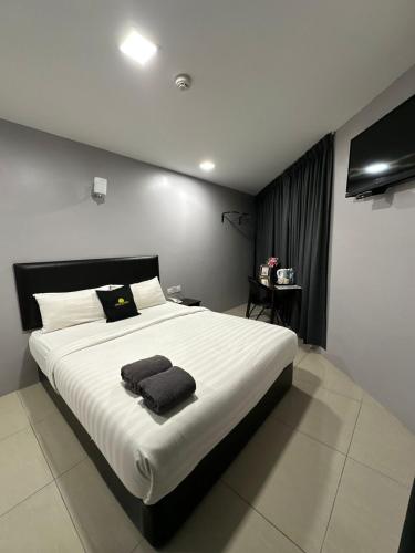 a bedroom with a large bed with two towels on it at Royale City Hotel - 10 min from KLIA KLIA 2 Airport in Sepang