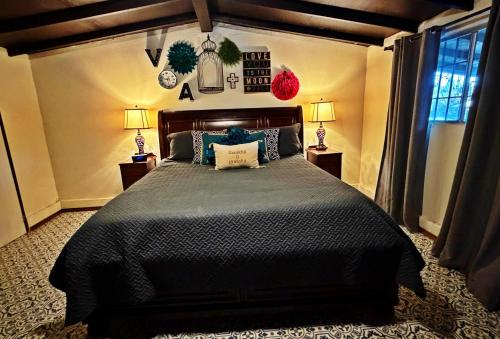 a bedroom with a large bed with a black comforter at Finca Vidandrei CASA EUCALIPTO in Valle de Guadalupe