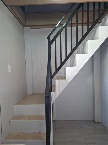 a staircase in a house with white walls at Nancy's Place in Caniton