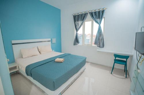 a bedroom with a bed and a desk and a television at Hotel Pratisarawirya by The Loka in Surabaya