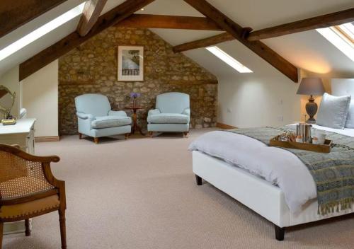 a bedroom with a bed and two chairs at The Hygge Out - Glamping Site in North Yorkshire in Ebberston
