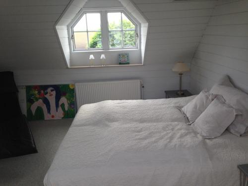 a bedroom with a white bed with a window at Country B&B Horsens in Horsens