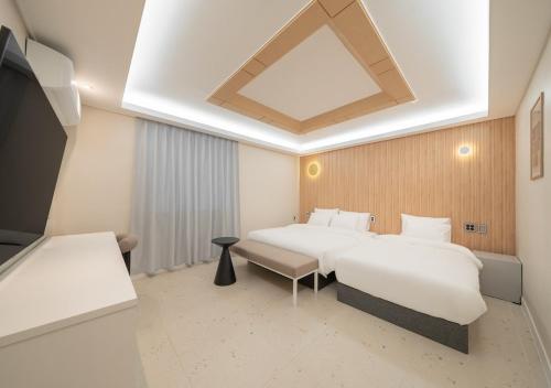 a hotel room with two beds and a tv at No 25 Iksan Station Branch in Iksan