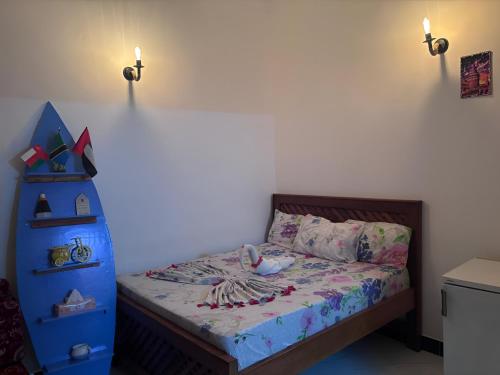 a small bedroom with a bed and a blue dresser at Yakamoz Zanzibar in Zanzibar City