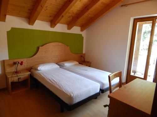een slaapkamer met 2 bedden en een groene muur bij Residence Vittoria in Pinzolo