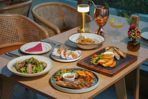 a wooden table with plates of food on it at Somerset Sukhumvit 71 Bangkok in Bangkok