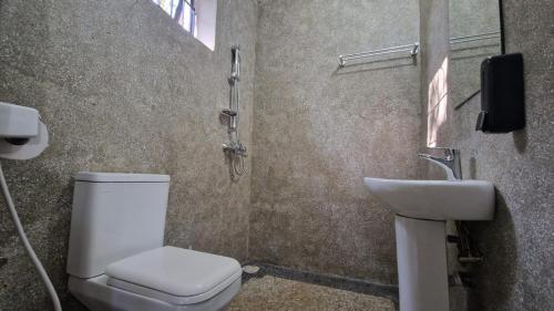 a bathroom with a toilet and a sink at Kilimanjaro Village Hotel in Mwika West