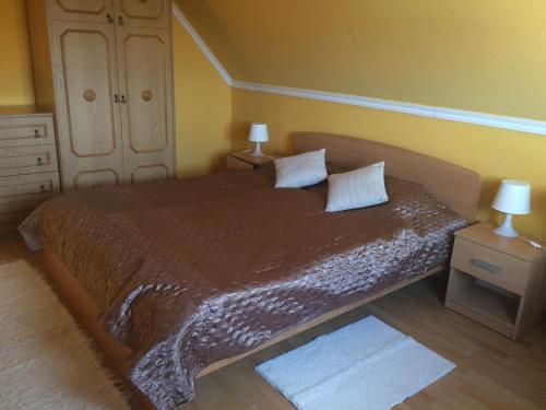 a bedroom with a large bed with two pillows at Kamilla Apartman in Fonyód