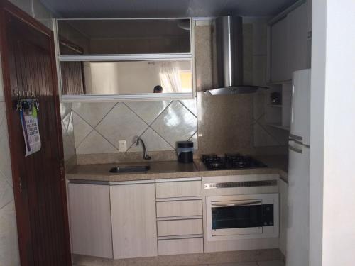 a small kitchen with a sink and a stove at Casa paraíso estaleirinho Balneário Camboriú in Balneário Camboriú