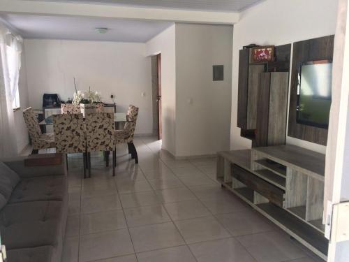 a dining room with a table and a television at Casa paraíso estaleirinho Balneário Camboriú in Balneário Camboriú