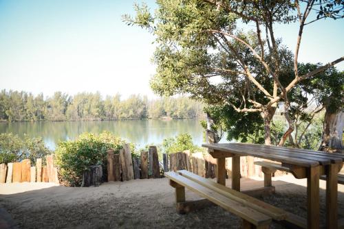 un banco de madera sentado frente a un lago en The Prawn Hatchery Pty Ltd on Amatikulu en Dokodweni