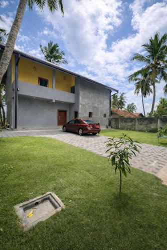 a car parked in front of a house at CocoBaru - Private Beachfront Entire Villa in Marawila
