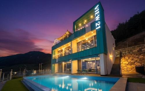 a building with a swimming pool at night at Yeosu View21 Pension in Yeosu