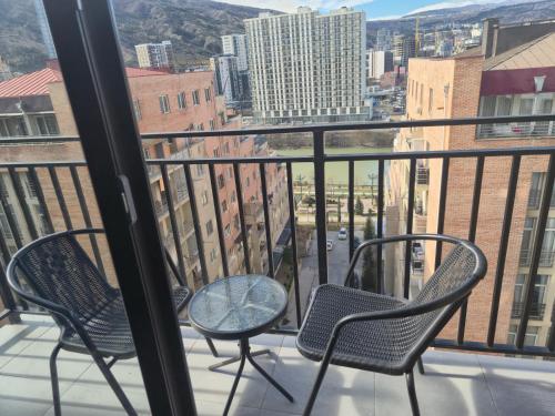 two chairs and a table on a balcony with a view at Address Inn in Tbilisi City