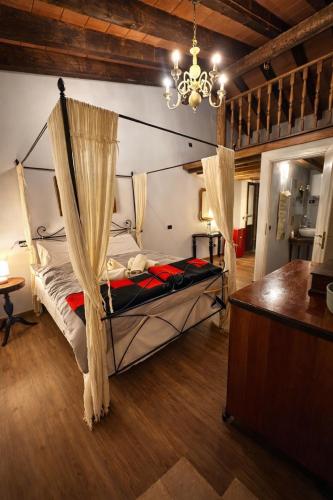 a bedroom with a canopy bed with a chandelier at B&B Il Casale Del Ginepro in Migliano