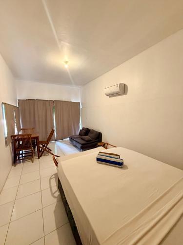 a bedroom with a bed and a couch and a table at Solara Gili Air in Gili Islands