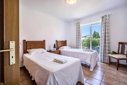 a hotel room with two beds and a window at Jardim da Meia Praia Resort in Lagos