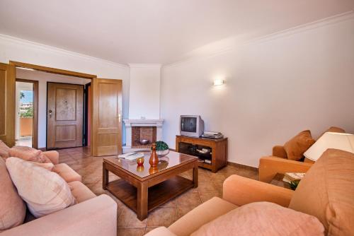 a living room with two couches and a coffee table at Jardim da Meia Praia Resort in Lagos