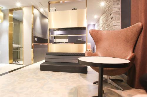 a living room with a chair and a table at Hotel Avant in Cheonan