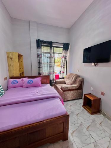 a bedroom with a bed and a flat screen tv at Mbogo Safari Hotel in Karatu