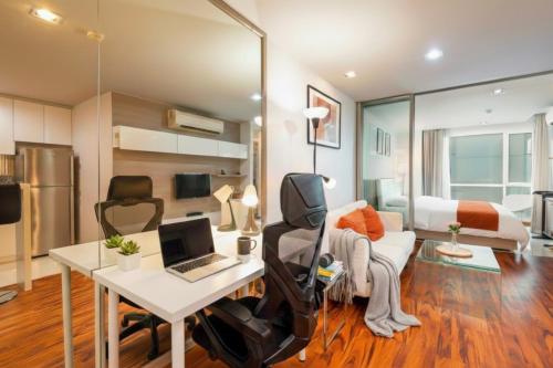 a room with a desk and a bed with a laptop at Designer Home BTS bangkok centre Pool Gym