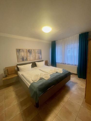 a bedroom with a large bed with blue curtains at Hotel Pommerscher Hof in Zinnowitz