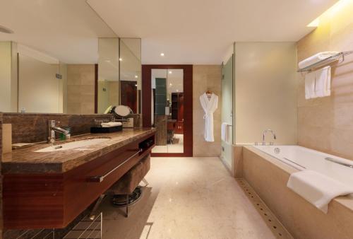 a bathroom with a large tub and a sink and a bath tub at Four Points by Sheraton Taicang in Taicang