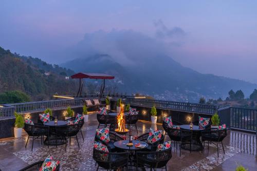 a restaurant with tables and chairs on a balcony at Perfectstayz Luxe kapilaz - Jacuzzi rooms in Bhowāli