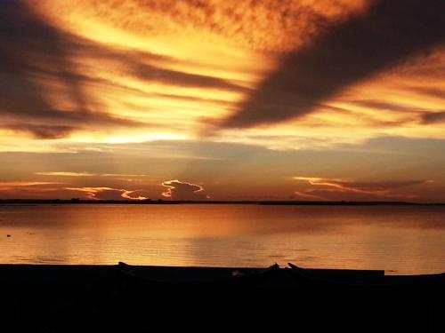 a sunset over a body of water with boats at Ocean Sky B&B in Huxi