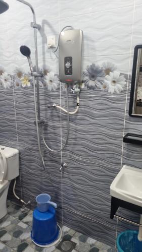 a shower in a bathroom with a toilet and a sink at SriStar in Kluang