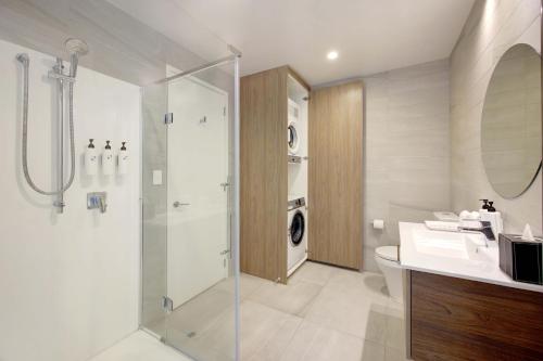 a bathroom with a shower and a sink and a toilet at Swiss-Belsuites Victoria Park Auckland in Auckland