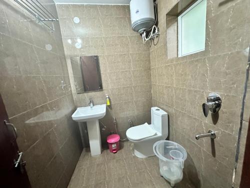 a small bathroom with a toilet and a sink at Hotel Clover Inn malsi in Dehradun