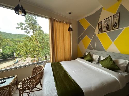 a bedroom with a bed and a large window at Hotel Clover Inn malsi in Dehradun