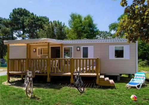 a tiny house with two bikes parked in the yard at ZEcamping 4 étoiles familial espace aquatique locatif TV LV clim in Sérignan