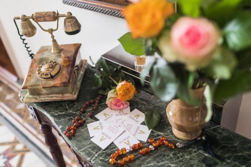 a table with a telephone and a vase of flowers at Sperveri Boutique Hotel in Rhodes Town