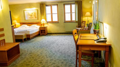 a hotel room with a bed and a desk at Altstadthotel Bräuwirt in Weiden
