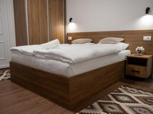 a bedroom with a large bed with white sheets at Megdan prenočište in Požarevac