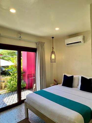 a bedroom with a large bed and a balcony at BIG WAVES BOUTIQUE HOTEL SIARGAO in General Luna