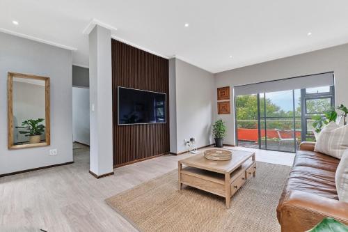 a living room with a couch and a table at Afrikaya Luxurious Apartment in Roodepoort