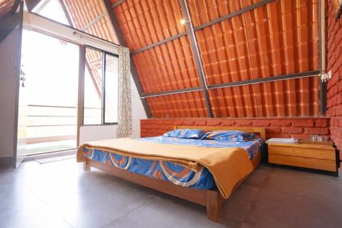 a bedroom with a bed and a large window at teak trail in Pune