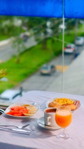 a table with two plates of food and a drink at Hotel Cristal Plaza in Popayan