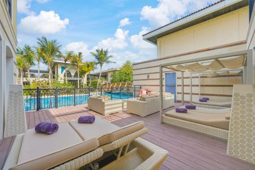an outdoor patio with beds and a pool at Zabeel Saray Royal Residences Lagoon Villa in Dubai